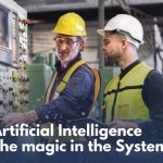 Zwei Arbeiter in einer industriellen Umgebung stehen vor einer großen, grünen Maschinensteuerung. Der ältere Mann mit gelbem Schutzhelm und Schutzweste bedient die Maschine und erklärt dem jüngeren Arbeiter mit weißem Helm und Weste etwas. Der Text „Artificial Intelligence – The magic in the System“ ist über das Bild gelegt, begleitet von goldenen und grünen Glitzereffekten.